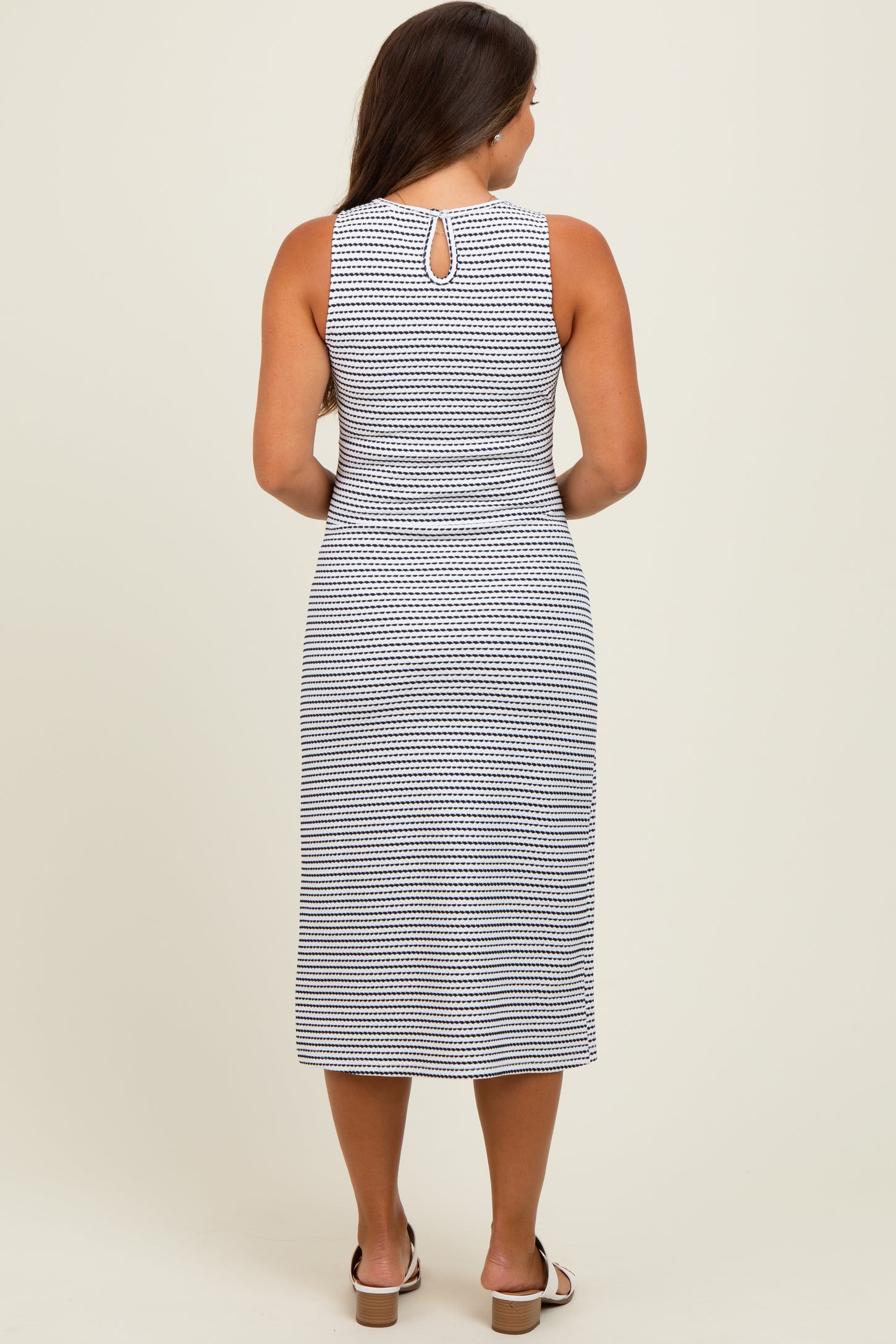 woman wearing a navy and white patterned maternity dress with a keyhole back detail