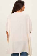 woman wearing a light beige maternity top with a loose fit and short sleeves, shown from the back
