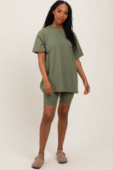woman wearing an oversized olive green t-shirt with matching bike shorts and tan slip-on shoes