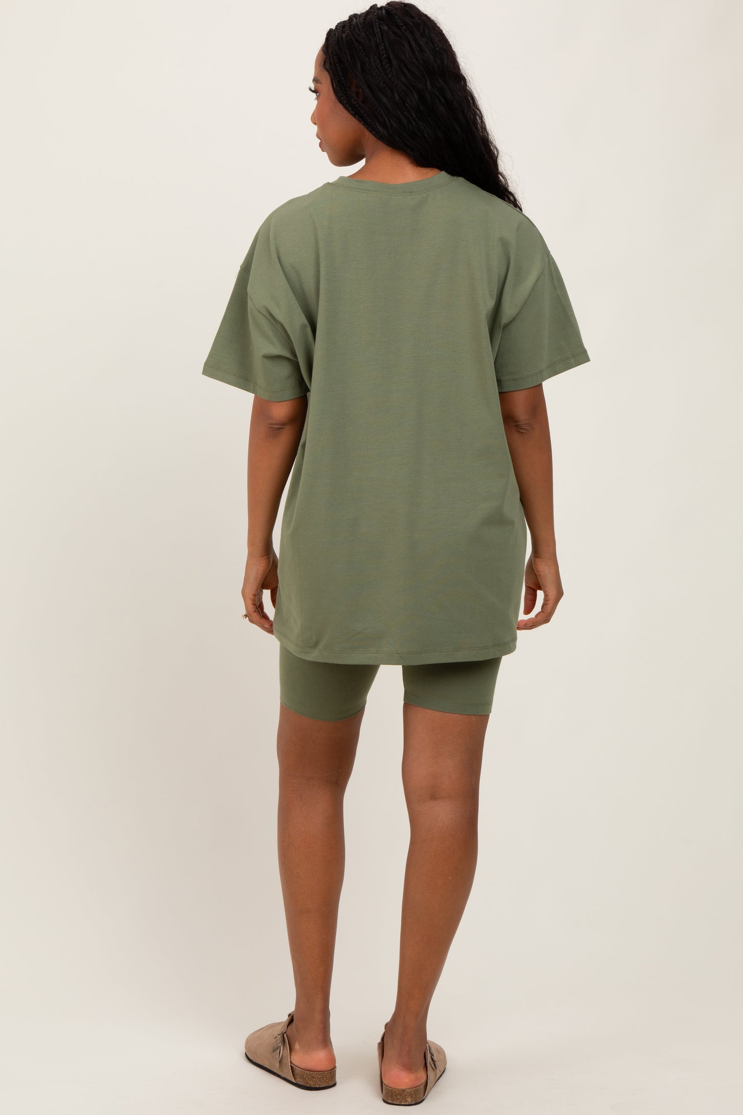 woman wearing an olive green oversized t-shirt with matching bike shorts, seen from the back