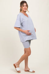 woman wearing a gray maternity t-shirt and matching shorts, highlighting her baby bump while standing sideways