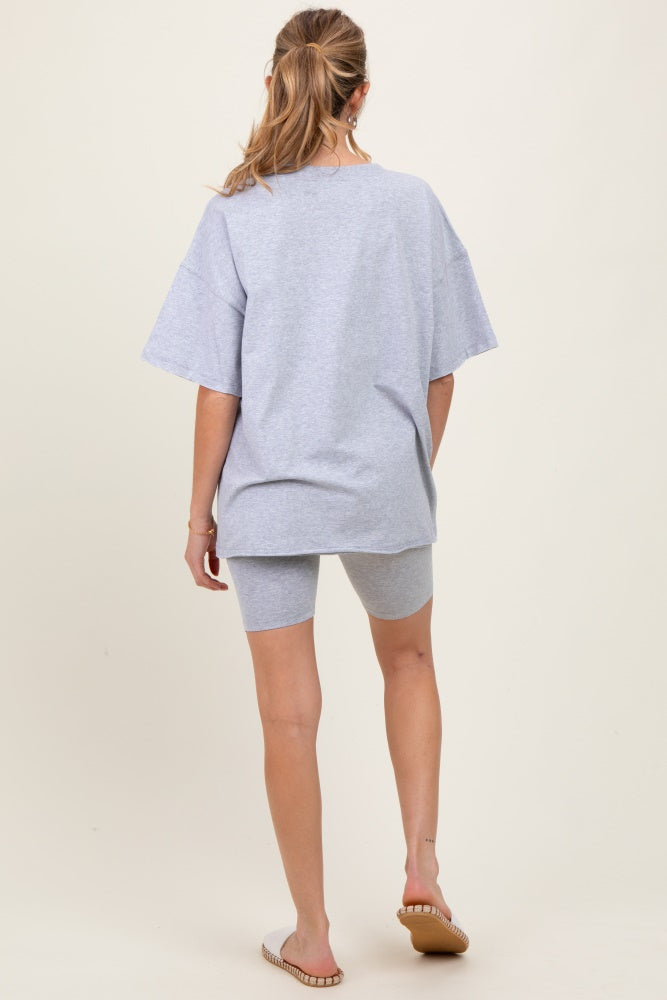 woman wearing a gray oversized maternity t-shirt and matching bike shorts, seen from the back