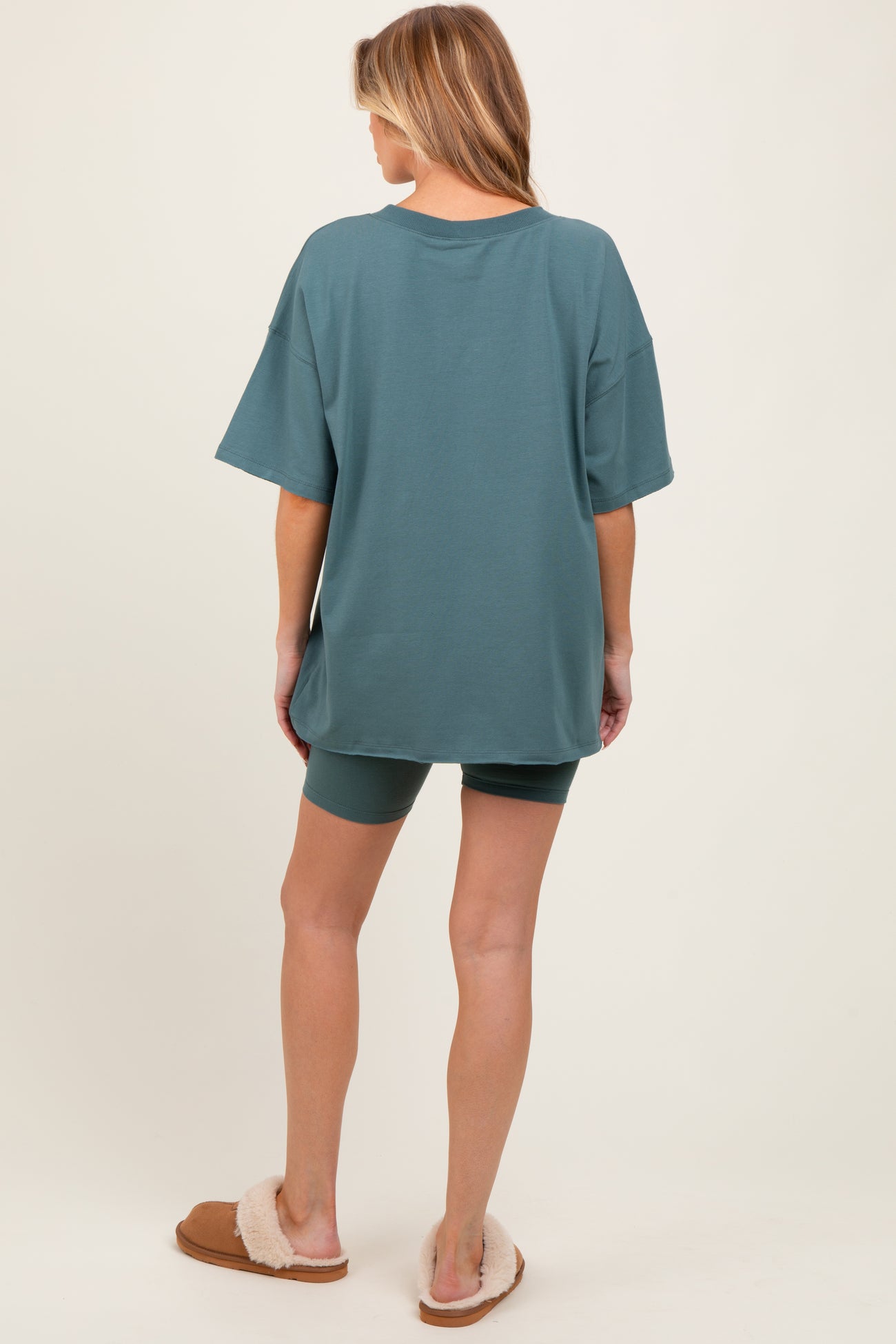 woman wearing a sea green oversized t-shirt with matching shorts, showcasing comfortable maternity loungewear.