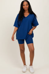 woman wearing a navy blue oversized v-neck t-shirt and matching bike shorts, paired with white sneakers