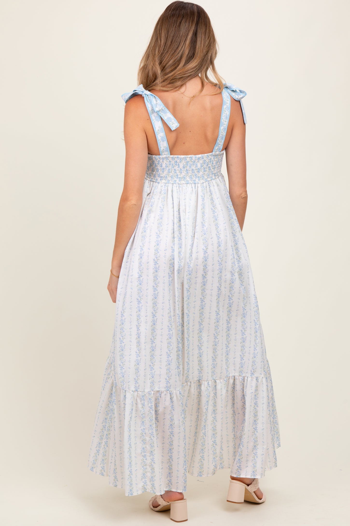woman wearing a blue and white striped maternity maxi dress with tie shoulder straps and smocked back