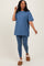 woman wearing a blue oversized t-shirt and matching leggings, paired with cozy slippers, standing and smiling