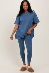 woman wearing a blue oversized t-shirt and matching leggings, paired with fluffy slippers