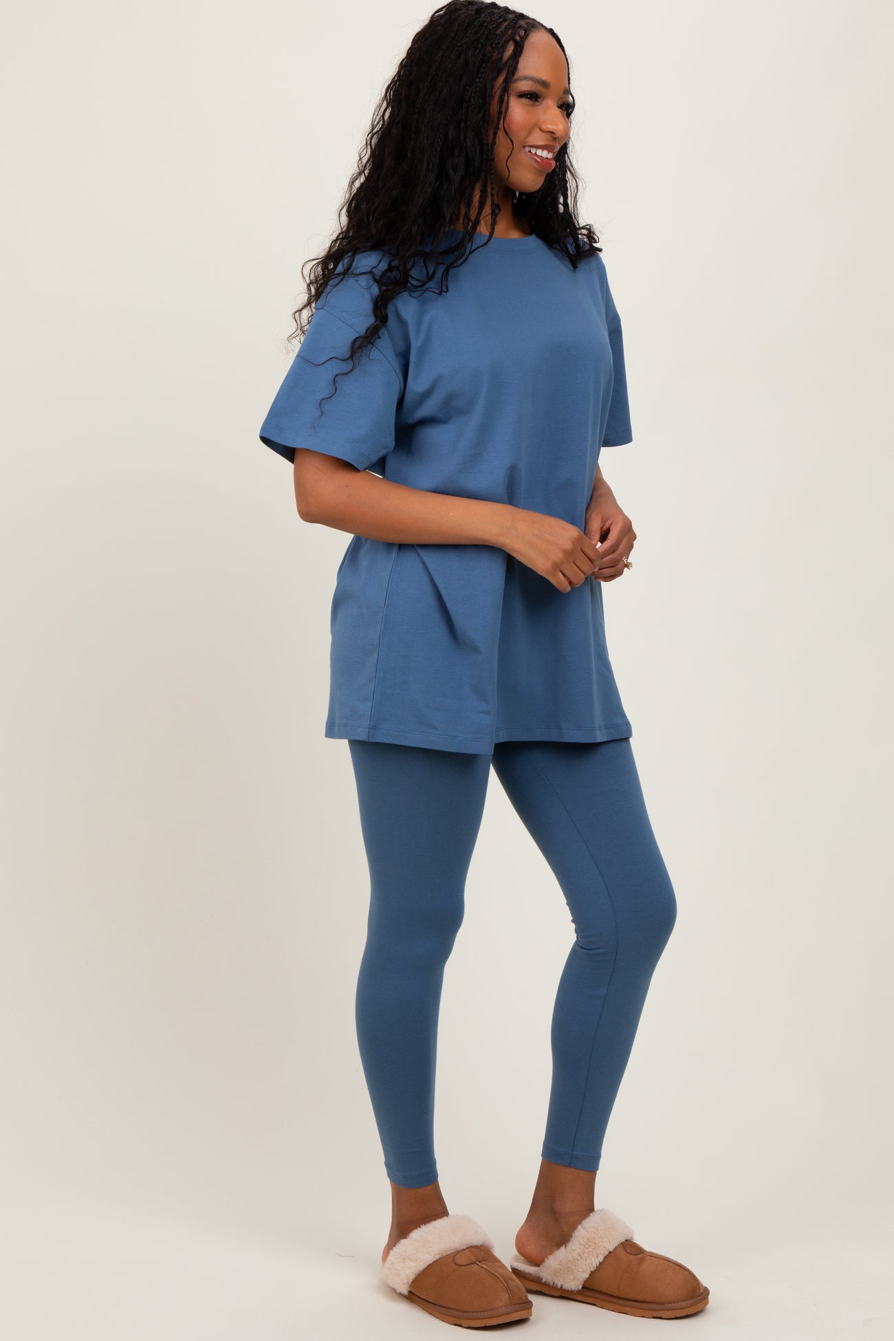 woman wearing a blue oversized t-shirt and matching leggings, paired with cozy slippers