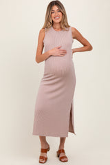 woman wearing a blush ribbed maternity dress with a side slit and holding her baby bump