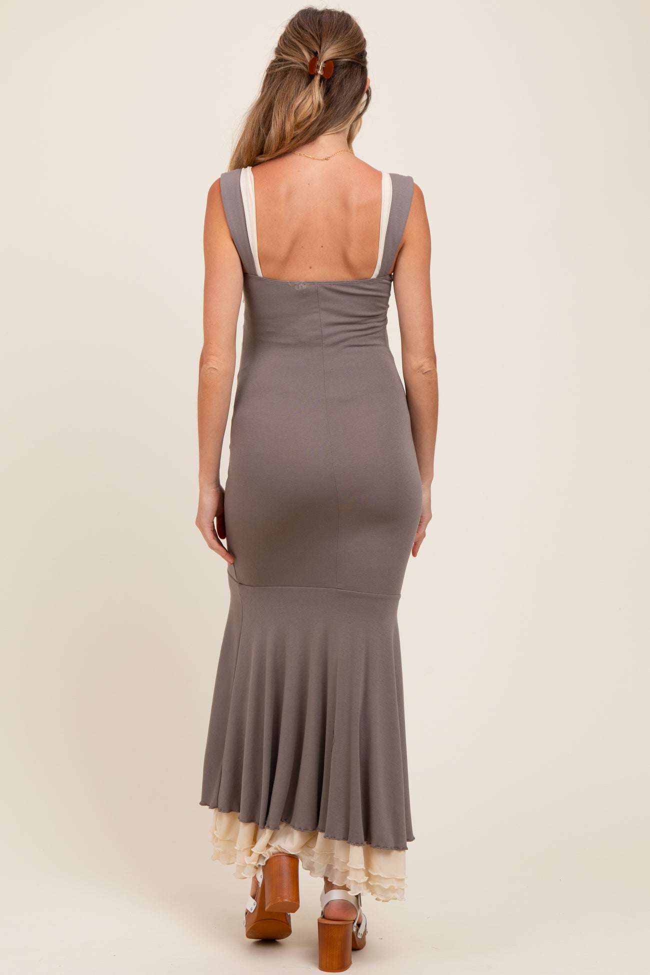 woman wearing a gray maternity dress with a fitted silhouette and flared skirt viewed from the back