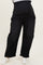 woman wearing black maternity plus wide-leg jeans with a stretchy waistband and rolled cuffs, white sneakers on feet