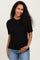 woman wearing a black ribbed short sleeve maternity top and holding her baby bump