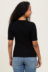 woman wearing a black ribbed short sleeve maternity top, seen from the back, paired with blue jeans