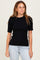 woman wearing a black ribbed short sleeve fitted top and light blue jeans