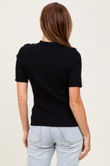 woman wearing a black ribbed short sleeve top with a fitted silhouette and round neckline, viewed from the back