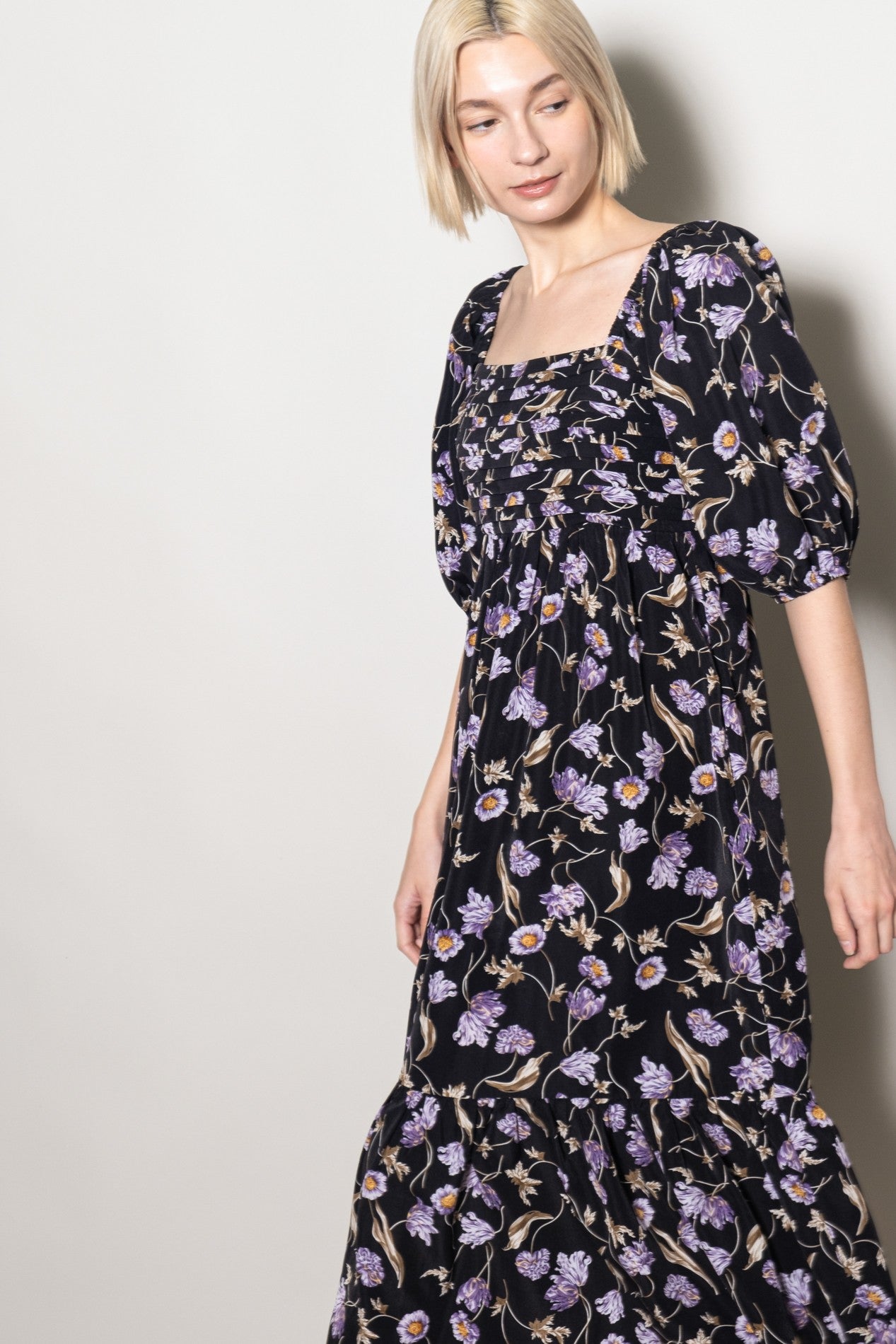 woman wearing a black floral maxi dress with puff sleeves and a square neckline