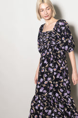 woman wearing a black floral maxi dress with puff sleeves and a square neckline