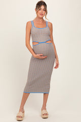 woman wearing a multicolored stripe maternity dress with cutout details and holding her baby bump
