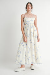 woman wearing a floral print maxi dress with spaghetti straps and a scalloped neckline