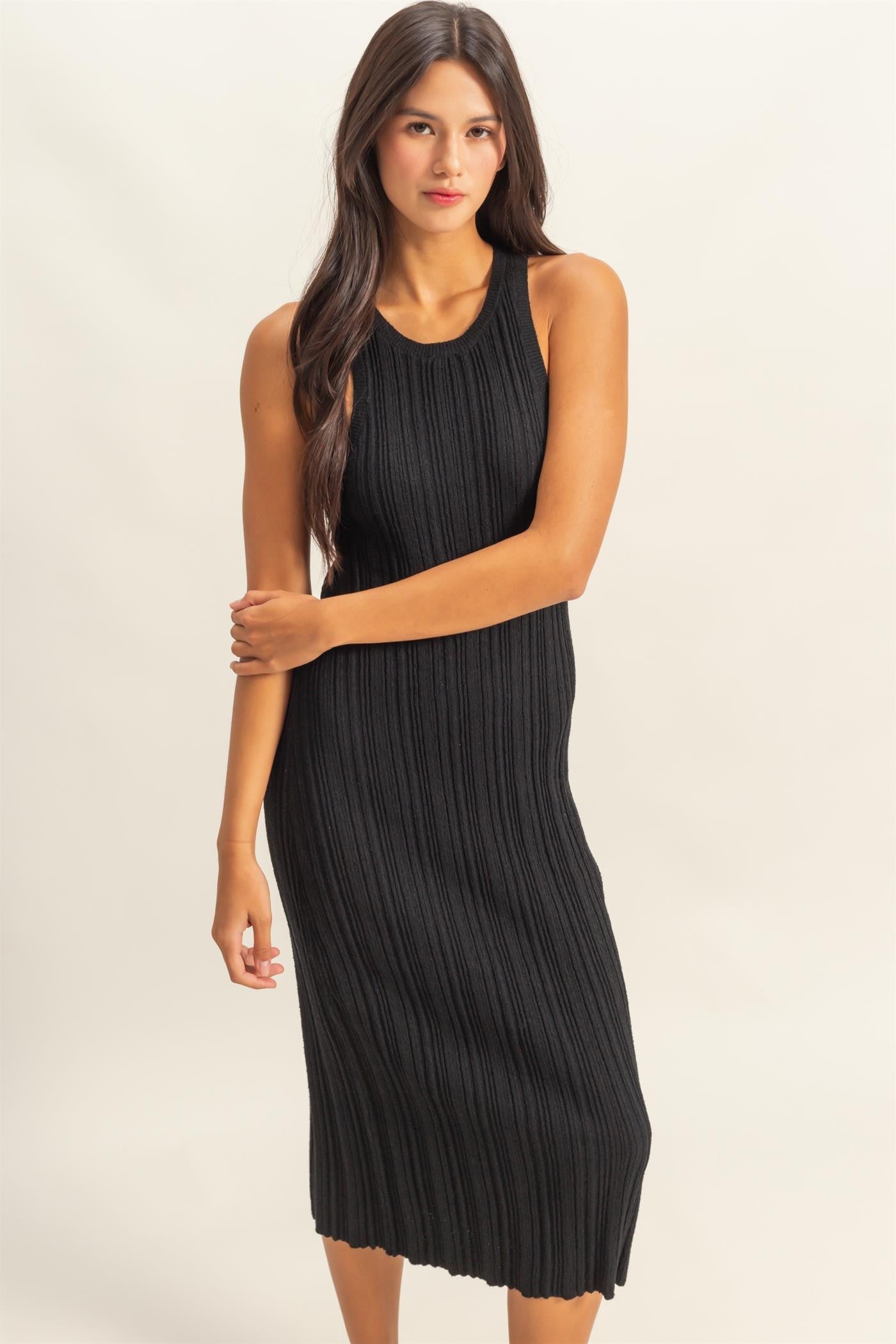 woman wearing a black ribbed knit midi dress with a sleeveless design and a fitted silhouette