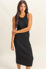 woman wearing a black ribbed knit midi dress with a sleeveless design and a fitted silhouette