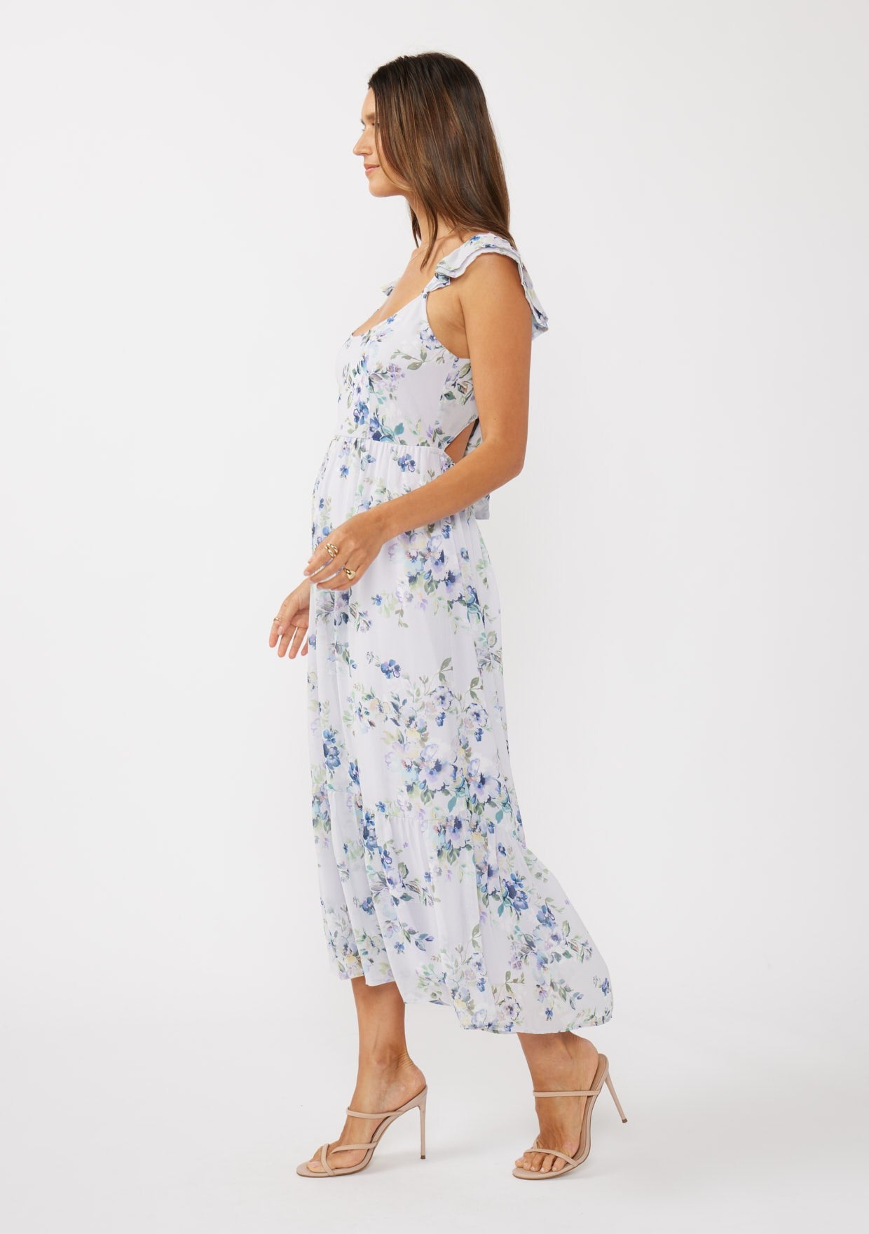 woman wearing a white floral midi dress with ruffle straps and a flowy silhouette