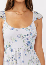 woman wearing a light floral print dress with ruffle straps and a square neckline