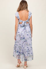 woman wearing a lavender floral maternity dress with ruffle sleeves and a tie-back detail