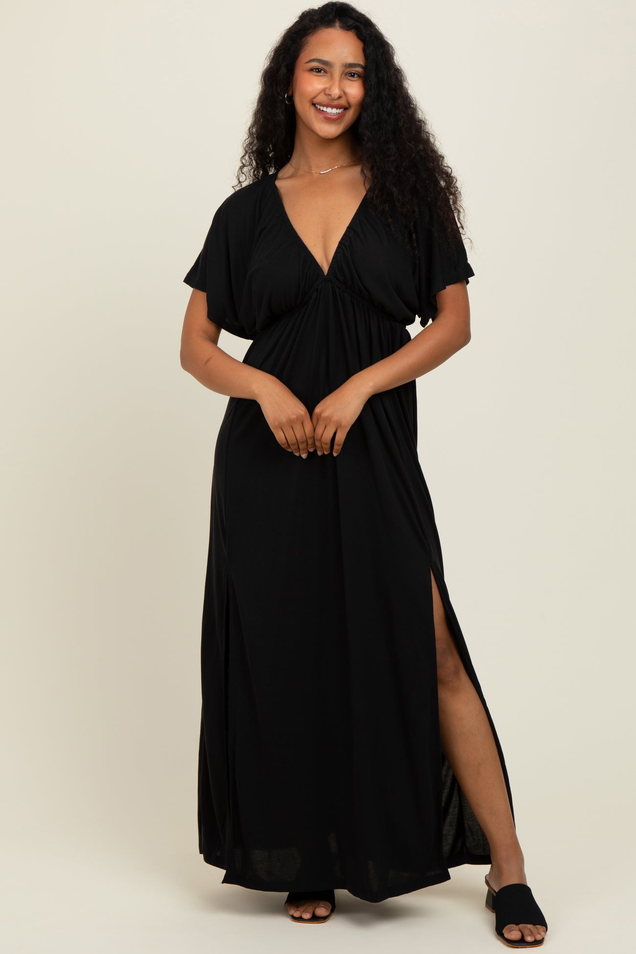 woman wearing a black maxi dress with a deep v-neck and side slits
