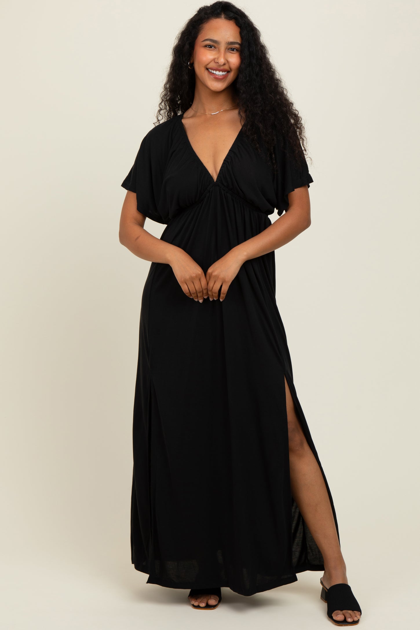 woman wearing a black maxi dress with a deep v-neck and side slits