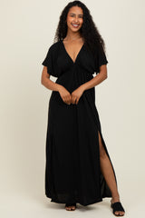 woman wearing a black maxi dress with a deep v-neck and side slits