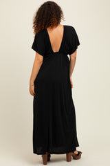 woman wearing a black maternity maxi dress with a deep v-back and short sleeves, showing her baby bump