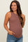 woman wearing a brown ribbed maternity tank top and showing her baby bump while smiling