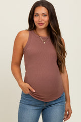 woman wearing a dusty rose sleeveless maternity top with a fitted style and holding her pregnant belly
