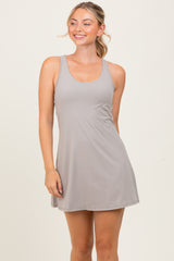 woman wearing a light gray sleeveless dress with a scoop neckline and a flared silhouette