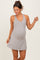 woman wearing a light gray maternity dress with a v-neckline and a relaxed fit, showcasing her baby bump