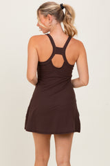 woman wearing a dark brown athletic dress with a racerback and ruched detailing on the back