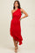 woman wearing a red one shoulder ruched dress with a ruffled hem line and standing with one hand on her hip