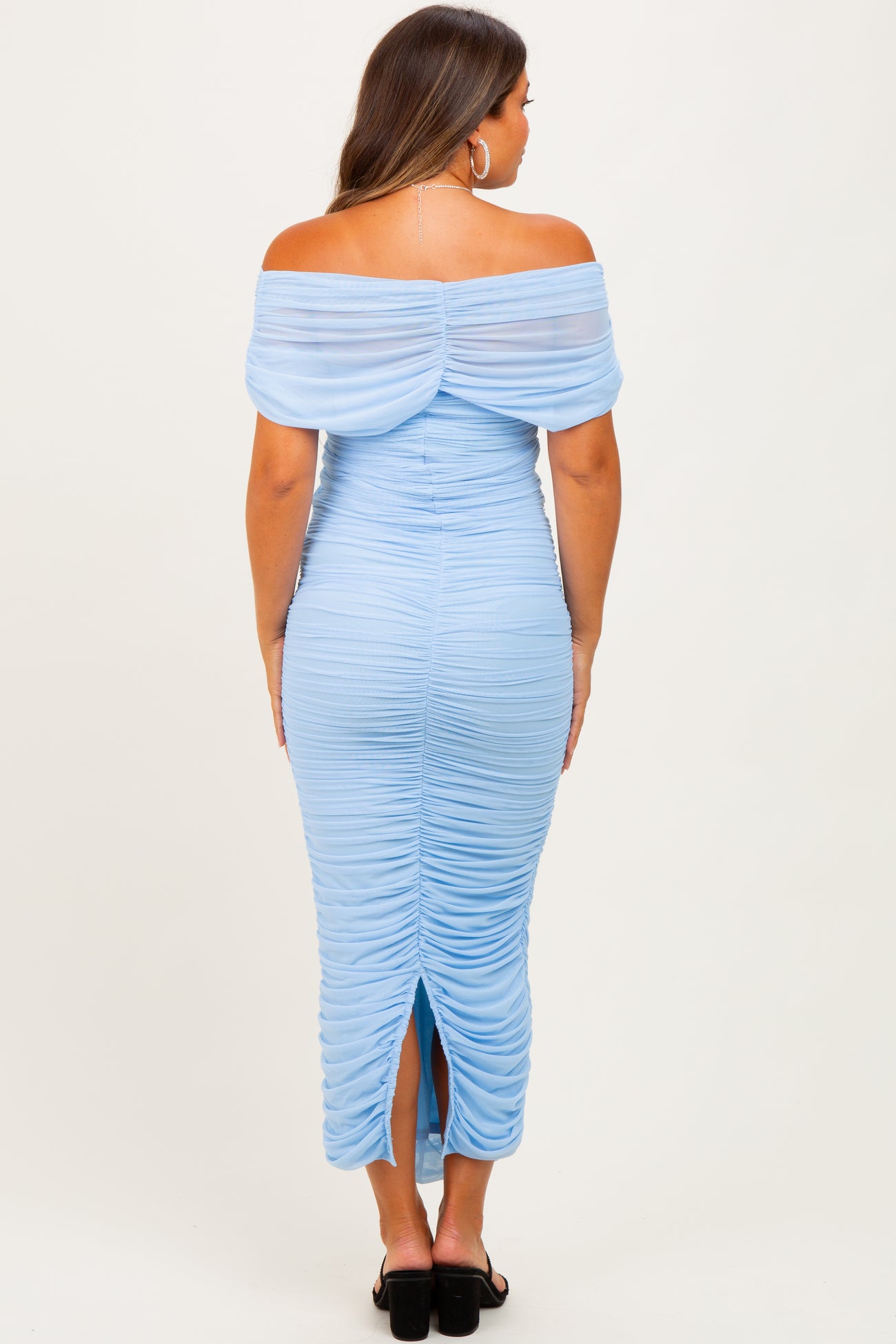 woman wearing a light blue off-shoulder maternity dress with ruching and a back slit