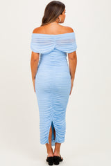 woman wearing a light blue off-shoulder maternity dress with ruching and a back slit