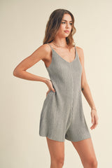 woman wearing a gray ribbed sleeveless romper with a v-neckline and side pockets