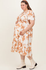 woman wearing a floral print maternity plus dress with short sleeves and a tiered skirt, showcasing her baby bump