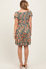 woman wearing a green floral print short sleeve dress with a smocked bodice and tiered skirt