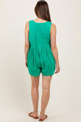 woman wearing a green maternity romper with pleated back detail and a relaxed fit