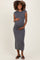 woman wearing a gray maternity midi dress and cradling her baby bump