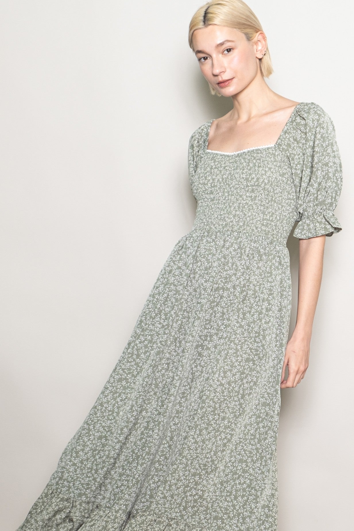 woman wearing a green floral maxi dress with puff sleeves and a square neckline