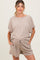 woman wearing a beige maternity short-sleeve top and matching drawstring shorts, featuring a relaxed fit and textured fabric