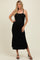 woman wearing a black maternity maxi dress with side slits and thin straps, showcasing her baby bump