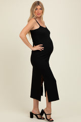 woman wearing a black maternity maxi dress with side slits and a visible baby bump