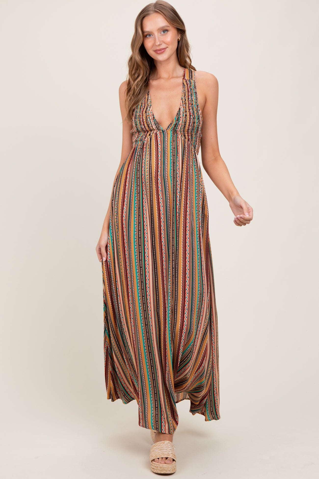 woman wearing a colorful patterned maxi dress with a deep V-neckline and braided straps